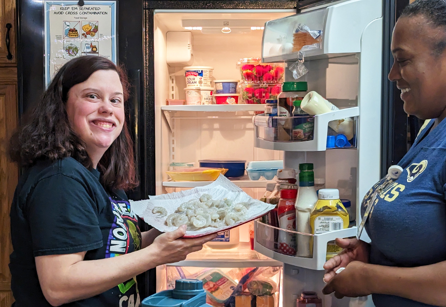 A resident pulls shrimp out of the fridge to be cooked.