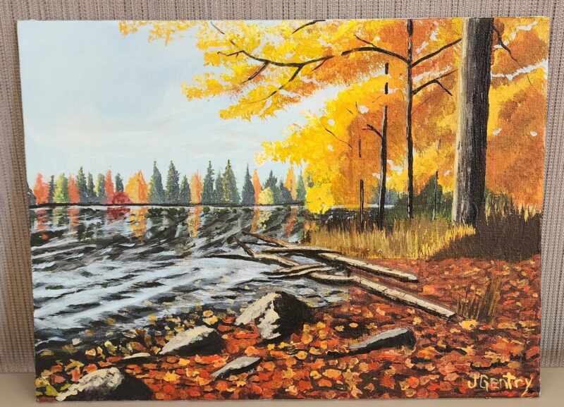 A painting of a serene autumn scene with orange and yellow trees reflecting on a calm lake, surrounded by fallen leaves and branches. Artwork signed by J. Gentry.