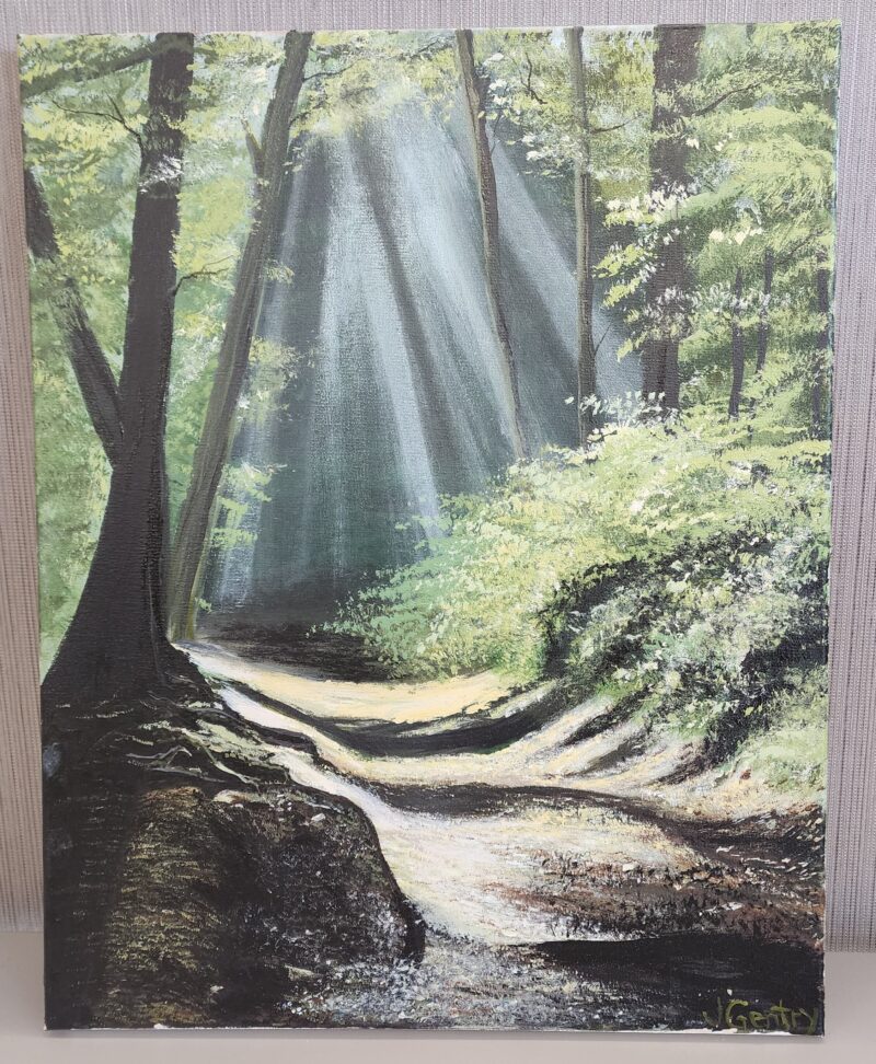  A painting of a forest path illuminated by beams of sunlight shining through the lush green trees. Artwork signed by J. Gentry.